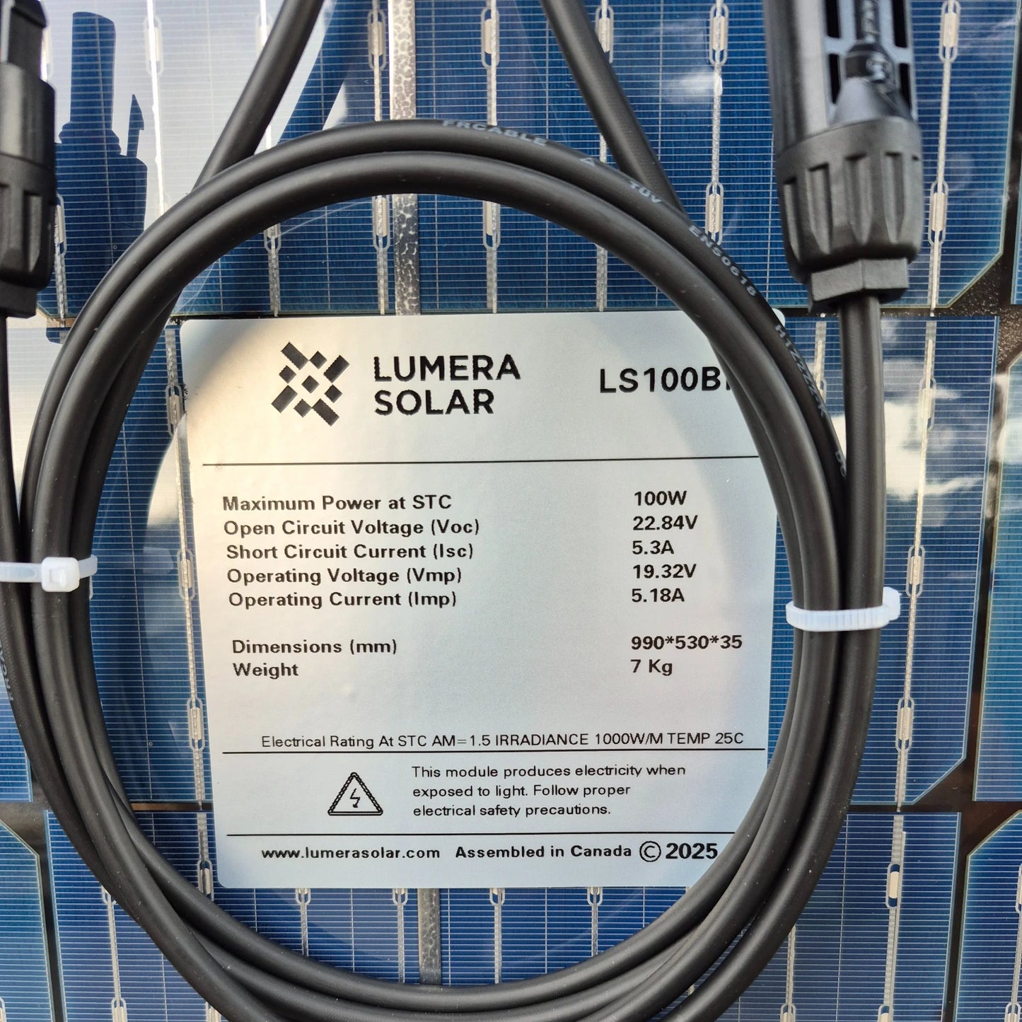 Lumera Solar LS100B solar panel with cable and specifications label against a solar panel background.