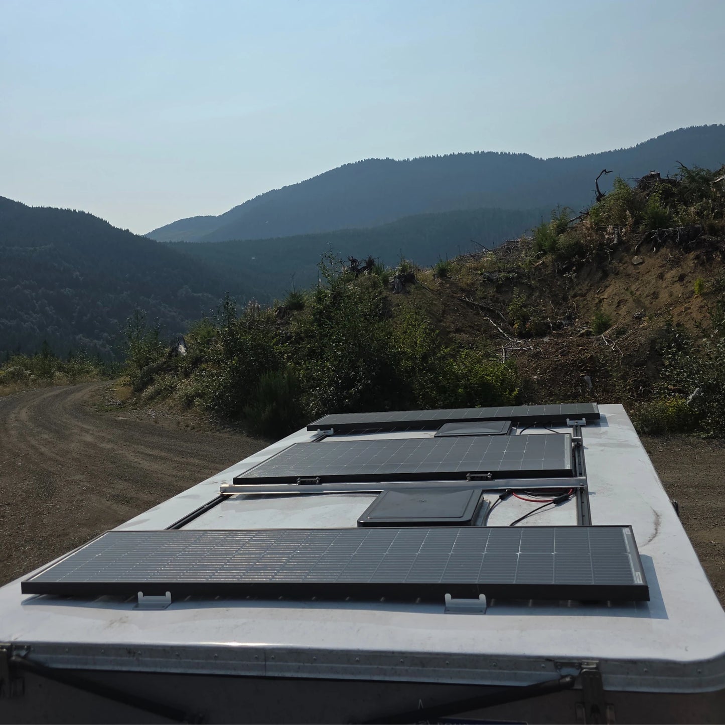 Lumera 220W & 140W Solar panels on the roof of a vehicle with a mountainous landscape in the background