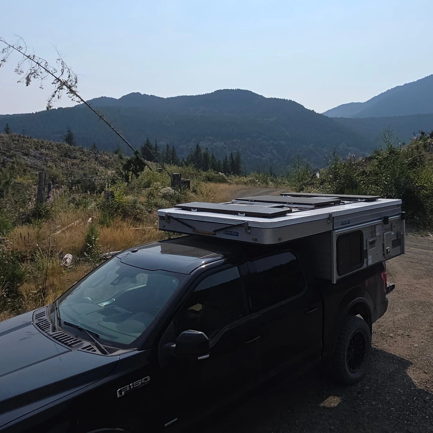 Black truck with a roof-mounted solar in a mountainous landscape