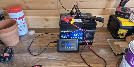 Sapphire Battery and charger plugged in on a wood workbench