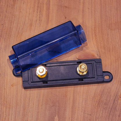Electrical component with blue cover and gold terminals on a wooden surface