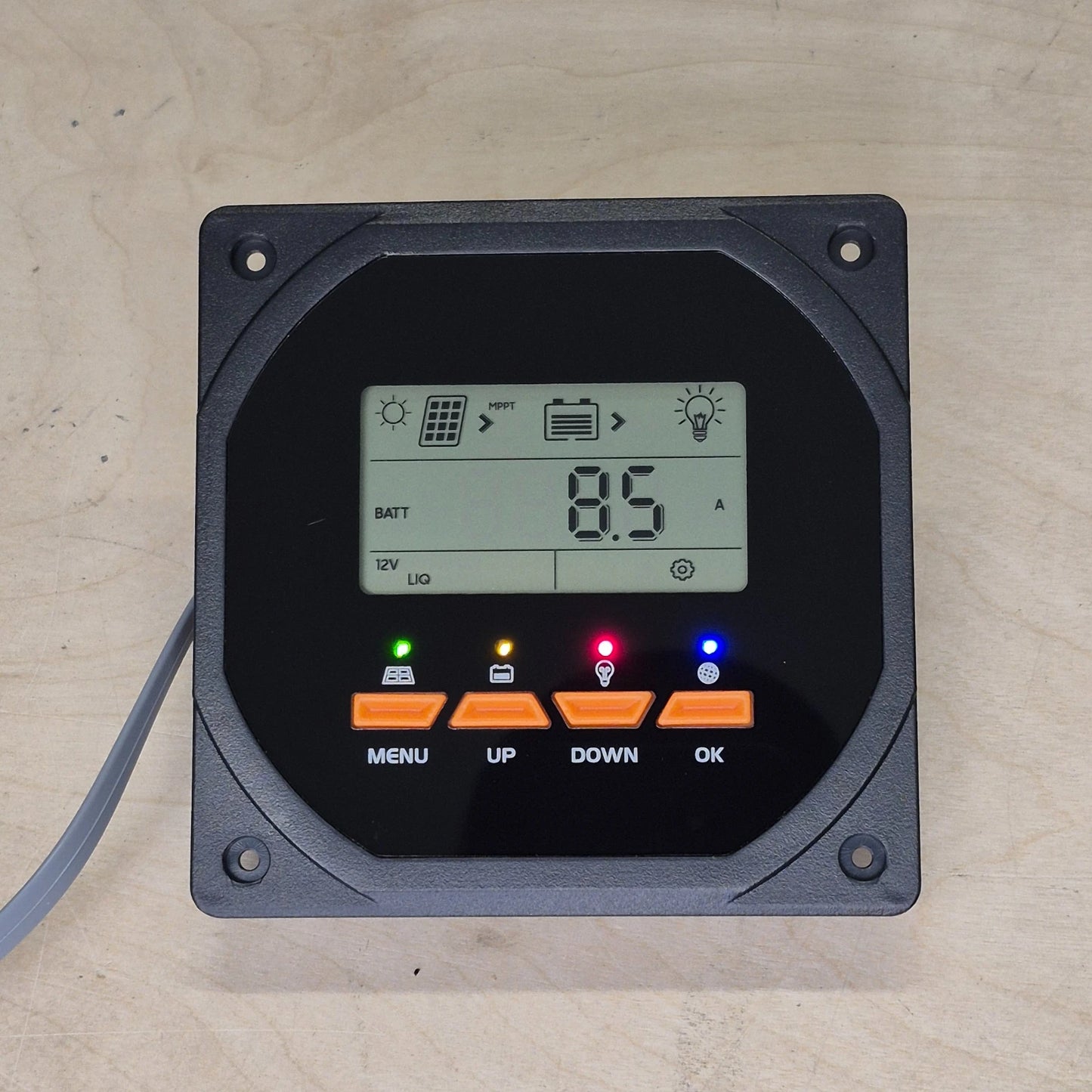 Digital display control panel with buttons on a wood surface