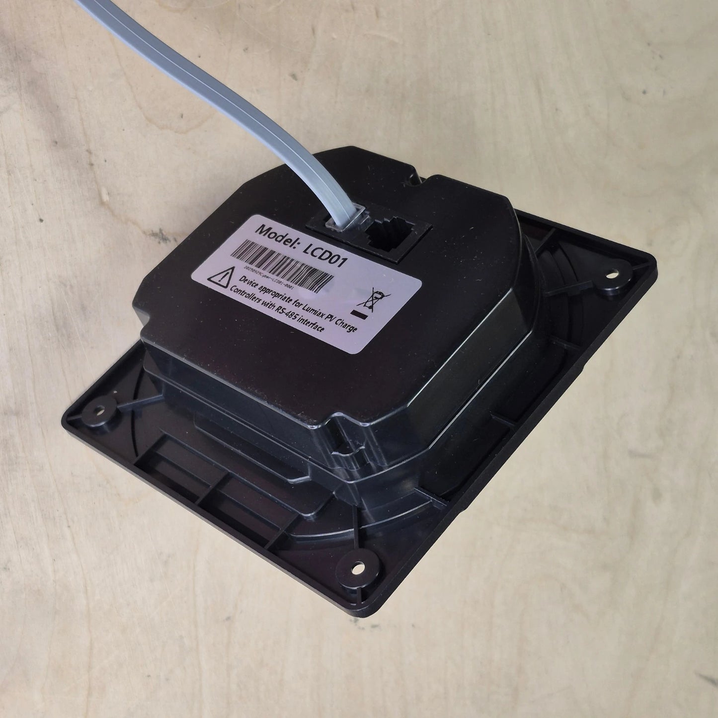 Black electronic component with a label on a wood surface