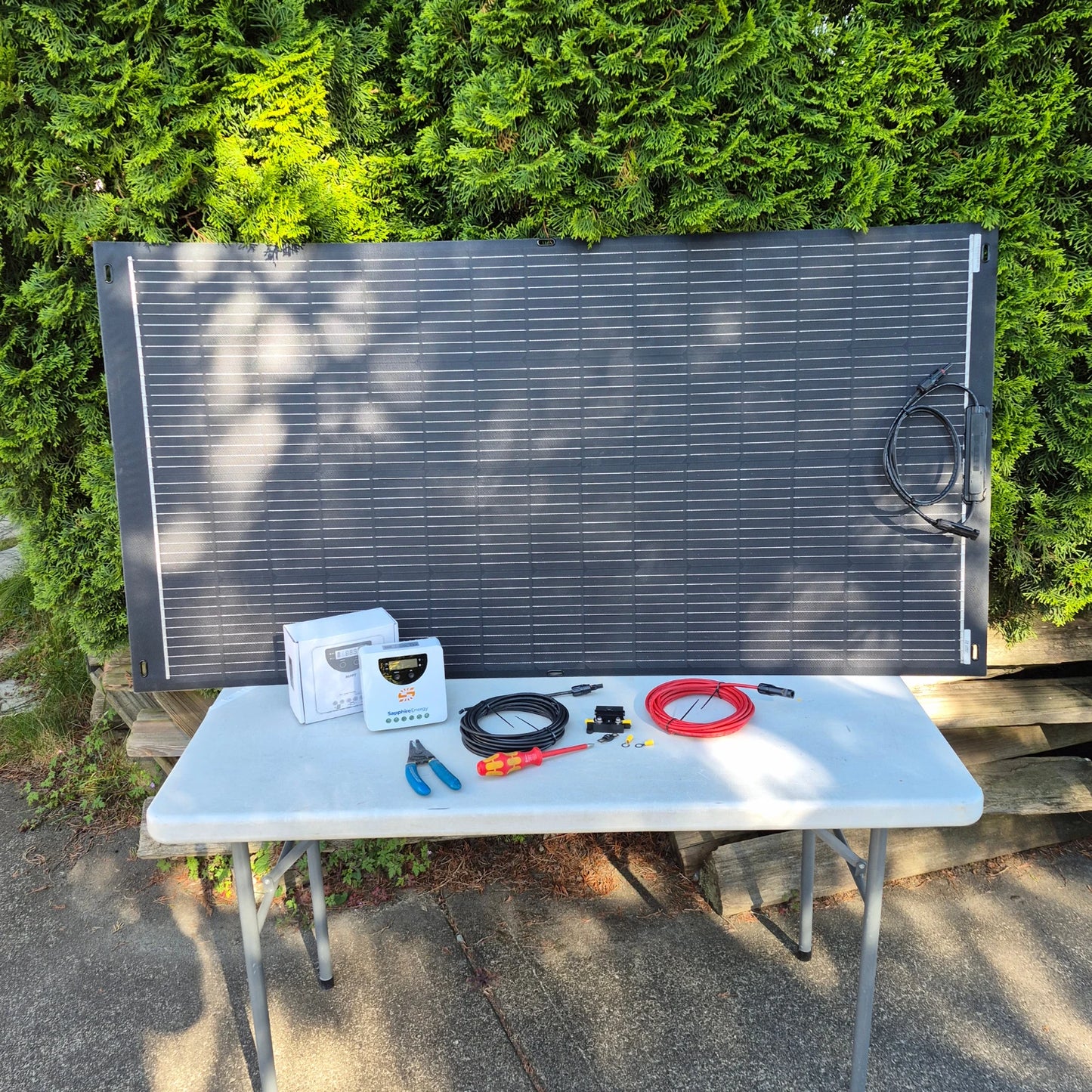 Solar panel on a table outdoors with tools and equipment.