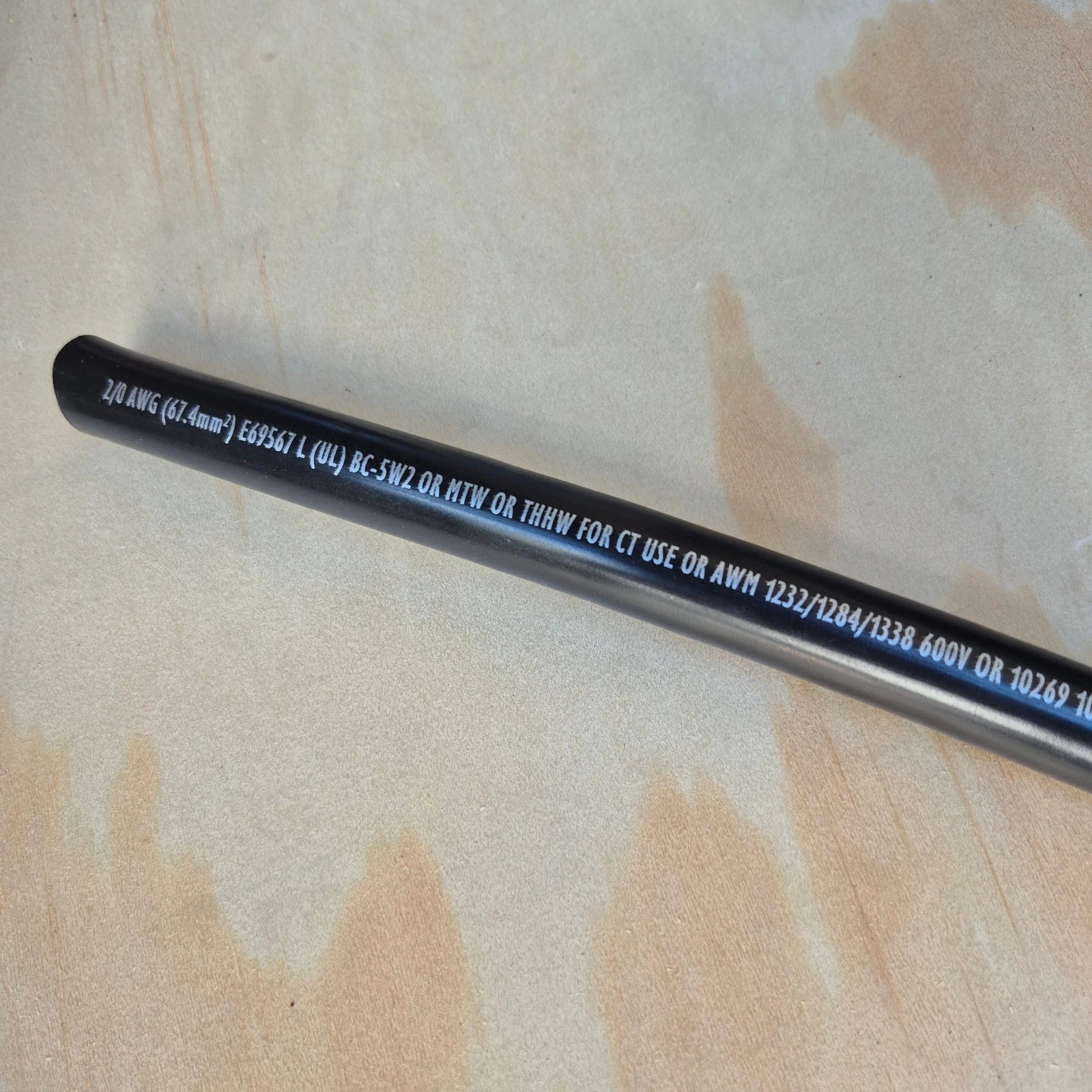 Marine Battery Cable w/ Printed text on outer jacket.  Cable is laying on a wood background.