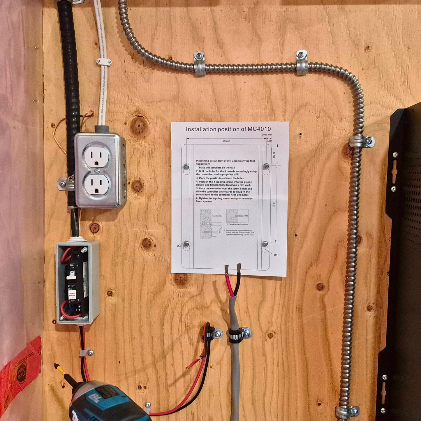 Installation template shown on plywood wall with other electrical devices surrounding it