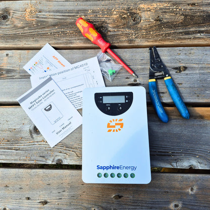 Sapphire Solar charge controller on wooden table with tools and documents